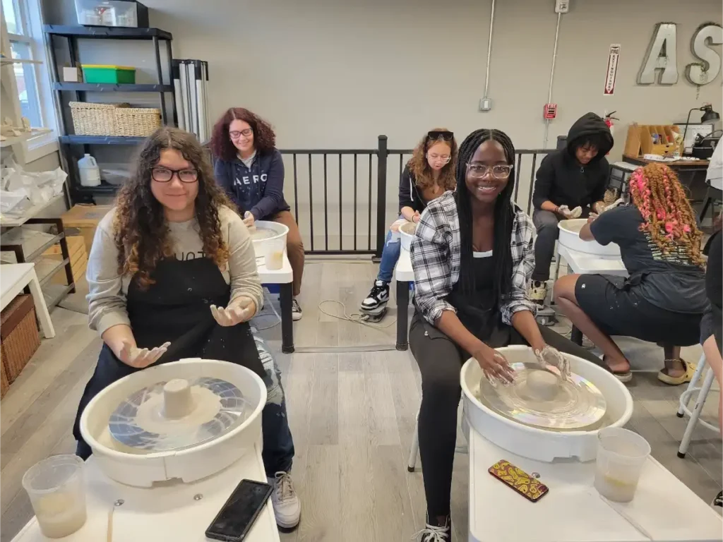 Teens making pottery at a Positive Directions event